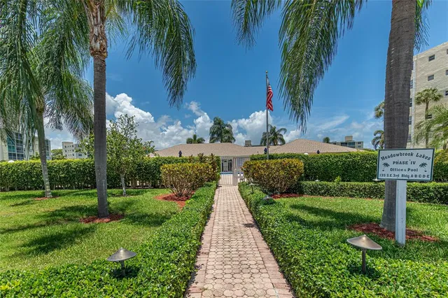 a front view of multi story residential apartment building with yard and outdoor seating