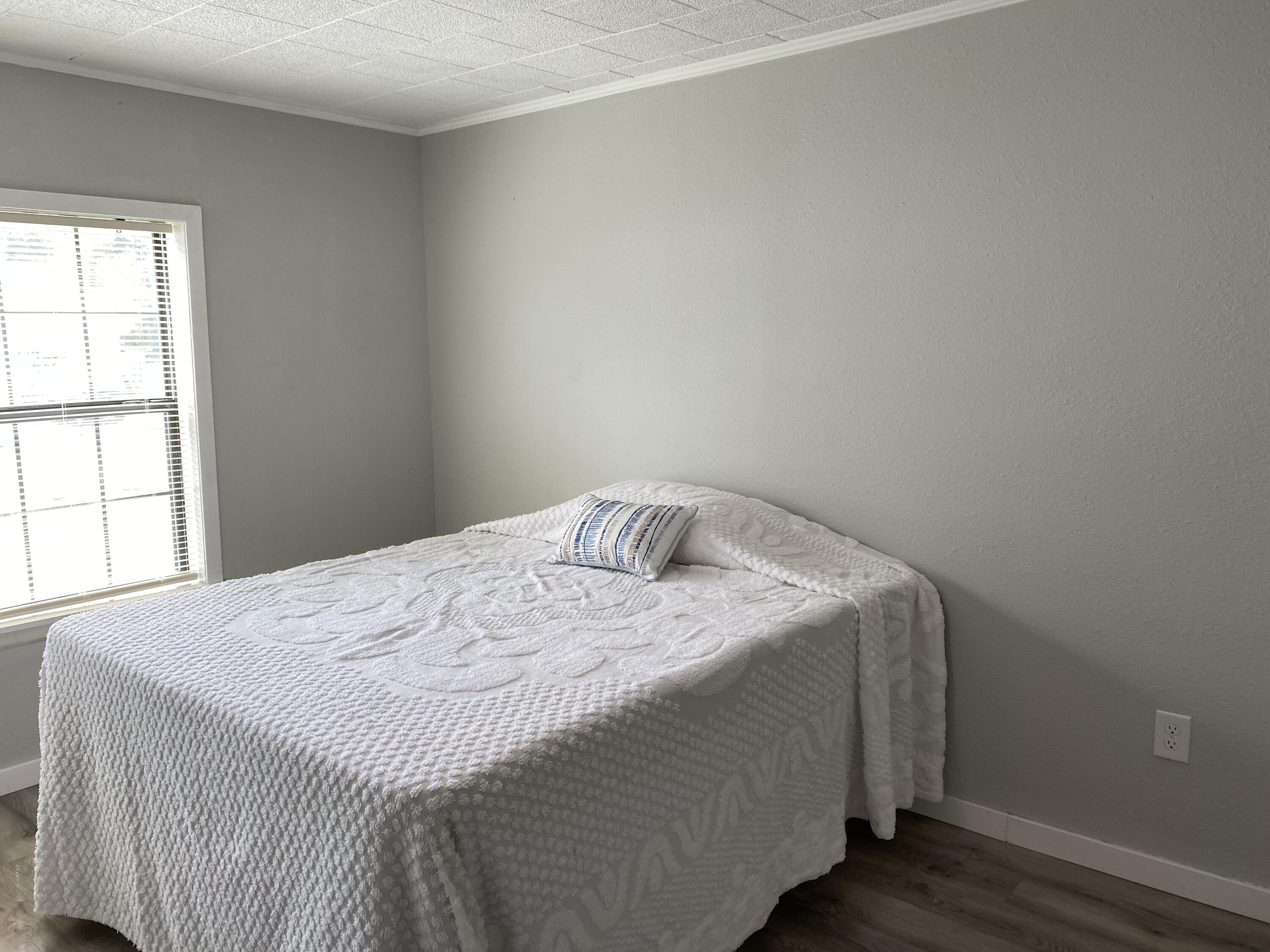 597 South Wilson Street Crestview, FL 32536 - Photo 11 of 16 a bedroom with a bed and wooden floor