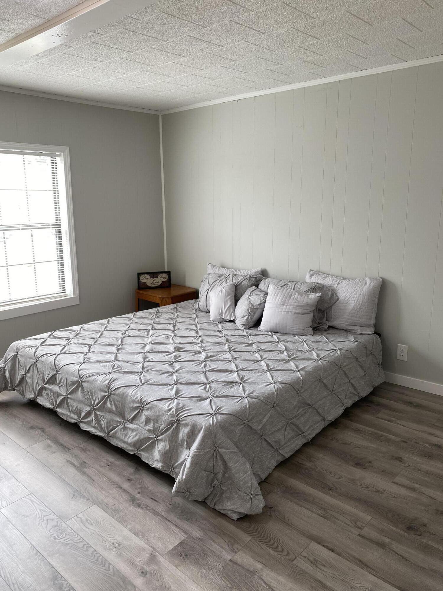 597 South Wilson Street Crestview, FL 32536 - Photo 13 of 16 a bedroom with a bed and wooden floor