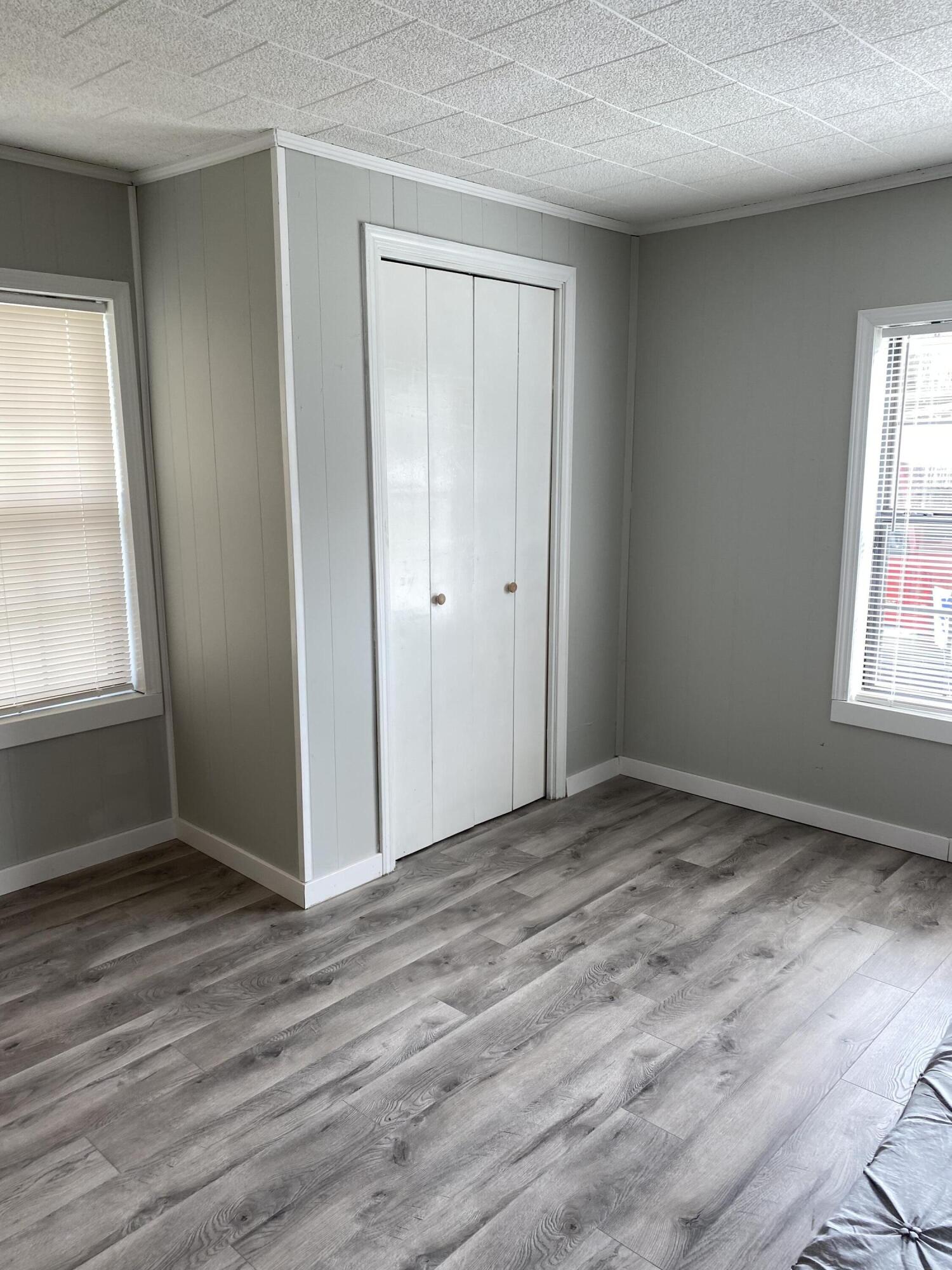 597 South Wilson Street Crestview, FL 32536 - Photo 14 of 16 an empty room with wooden floor and windows