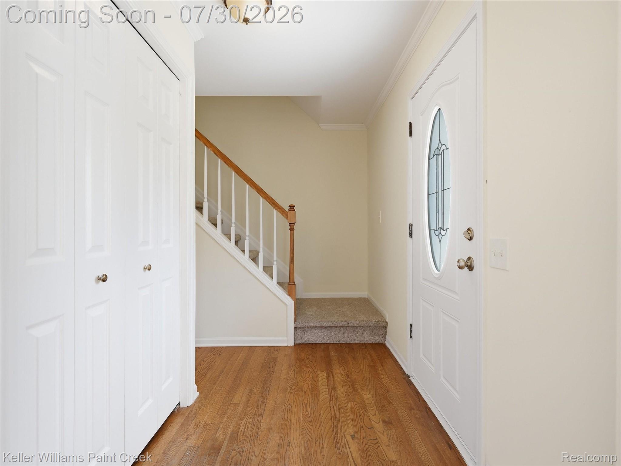 543 Arlington Drive Rochester, MI 48307 - Photo 3 of 59 Entryway featuring wood-finish flooring, a white front door with decorative glass, and a staircase with wood railing and carpeted treads