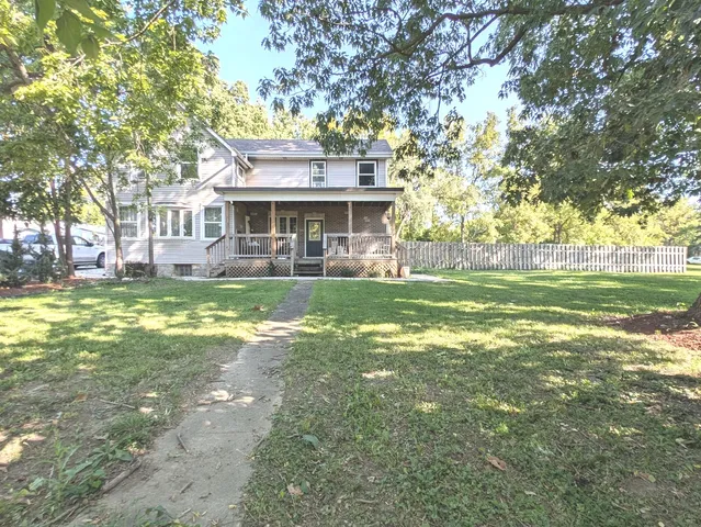a view of a house with a big yard and large trees