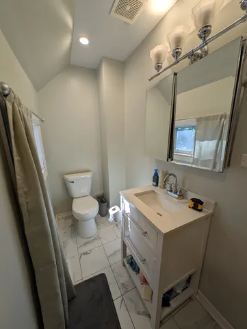 a bathroom with a sink a toilet a mirror and vanity