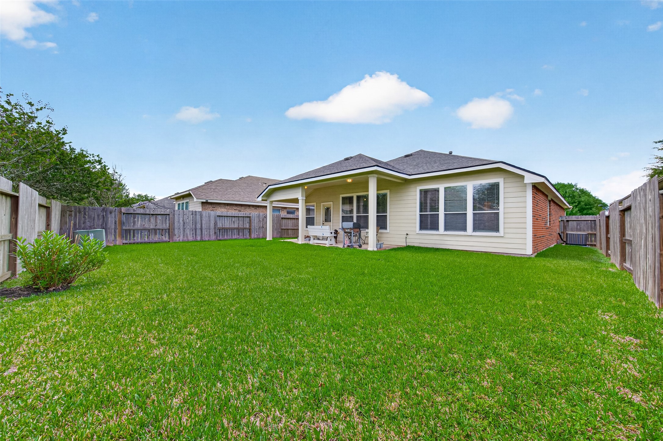 8622 Henrico Lane Rosenberg, TX 77469 - Photo 18 of 20 Featuring a cozy backyard with a well-maintained lawn, a covered patio, and a fenced perimeter, ideal for outdoor relaxation and privacy.