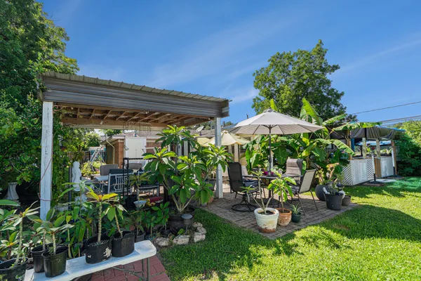 a view of a patio with chairs and potted plants