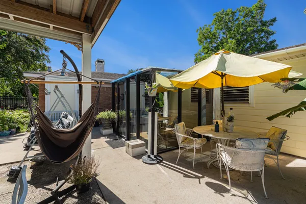 a view of a patio with table and chairs under an umbrella