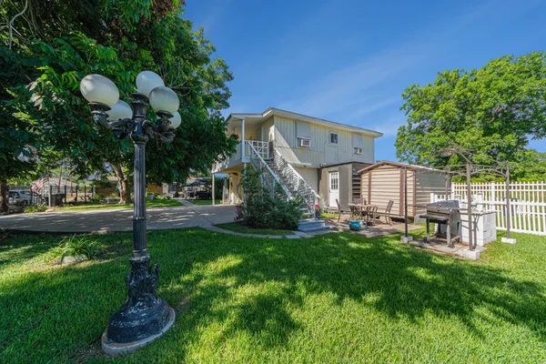 a front view of a house with garden and trees