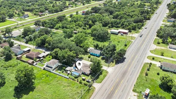 an aerial view of a house with a yard and outdoor seating