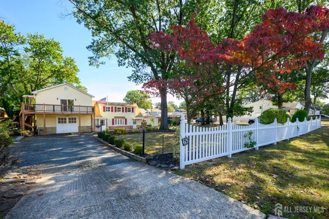 a view of house with backyard and trees