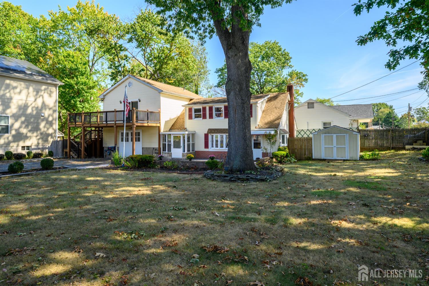 65 Orange Street Edison, NJ 08817 - Photo 5 of 51 a view of a yard in front of a house with a large tree