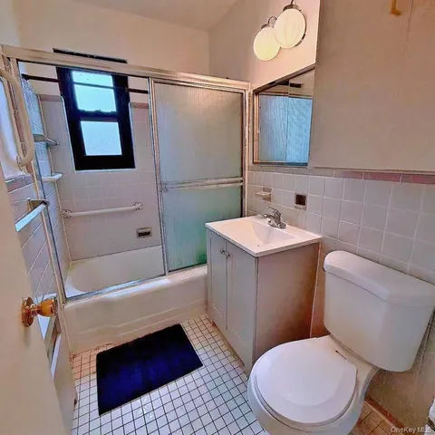 a bathroom with a sink a toilet a mirror and shower