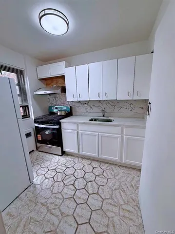 a kitchen with granite countertop a sink a stove a microwave and cabinets