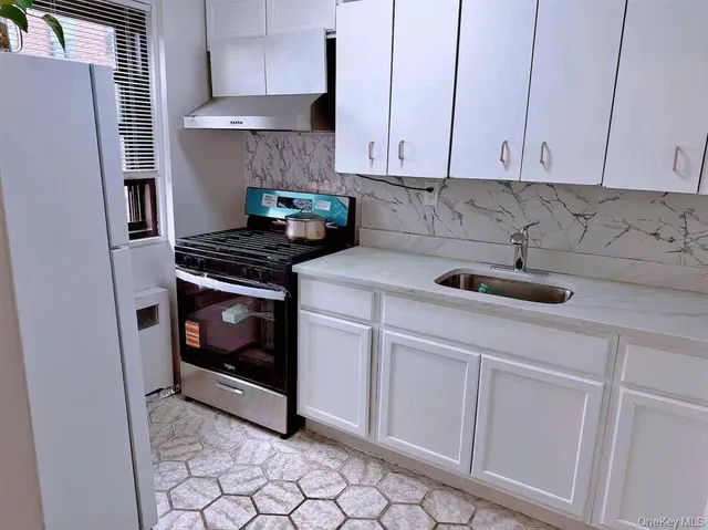 a kitchen with appliances a stove and cabinets