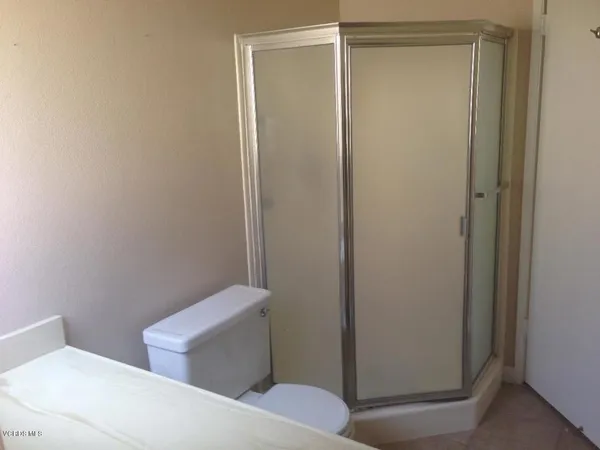 a white toilet sitting next to a shower