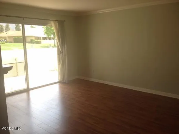 a view of a room with wooden floor and a window