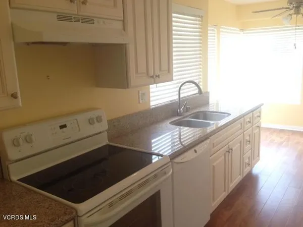 a kitchen with granite countertop a sink and a stove