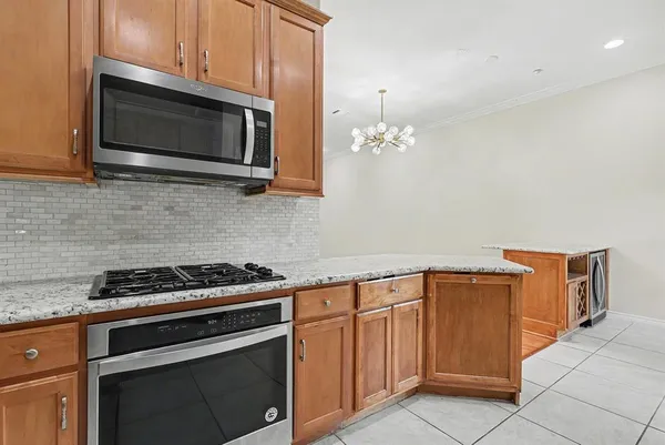 a kitchen with granite countertop cabinets stainless steel appliances and wooden cabinets