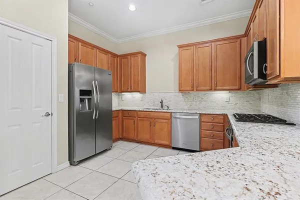 a kitchen with stainless steel appliances granite countertop a refrigerator sink and stove