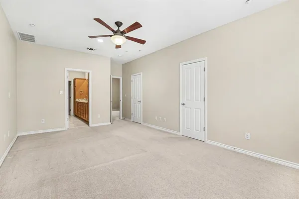 an empty room with closet and ceiling fan