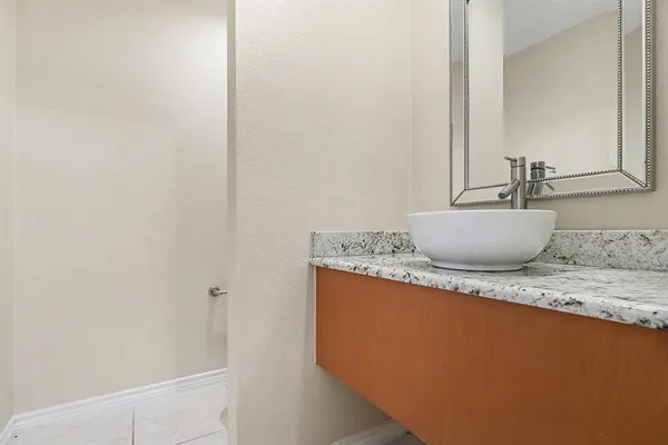 a view of bathroom with a granite countertop sink and a mirror