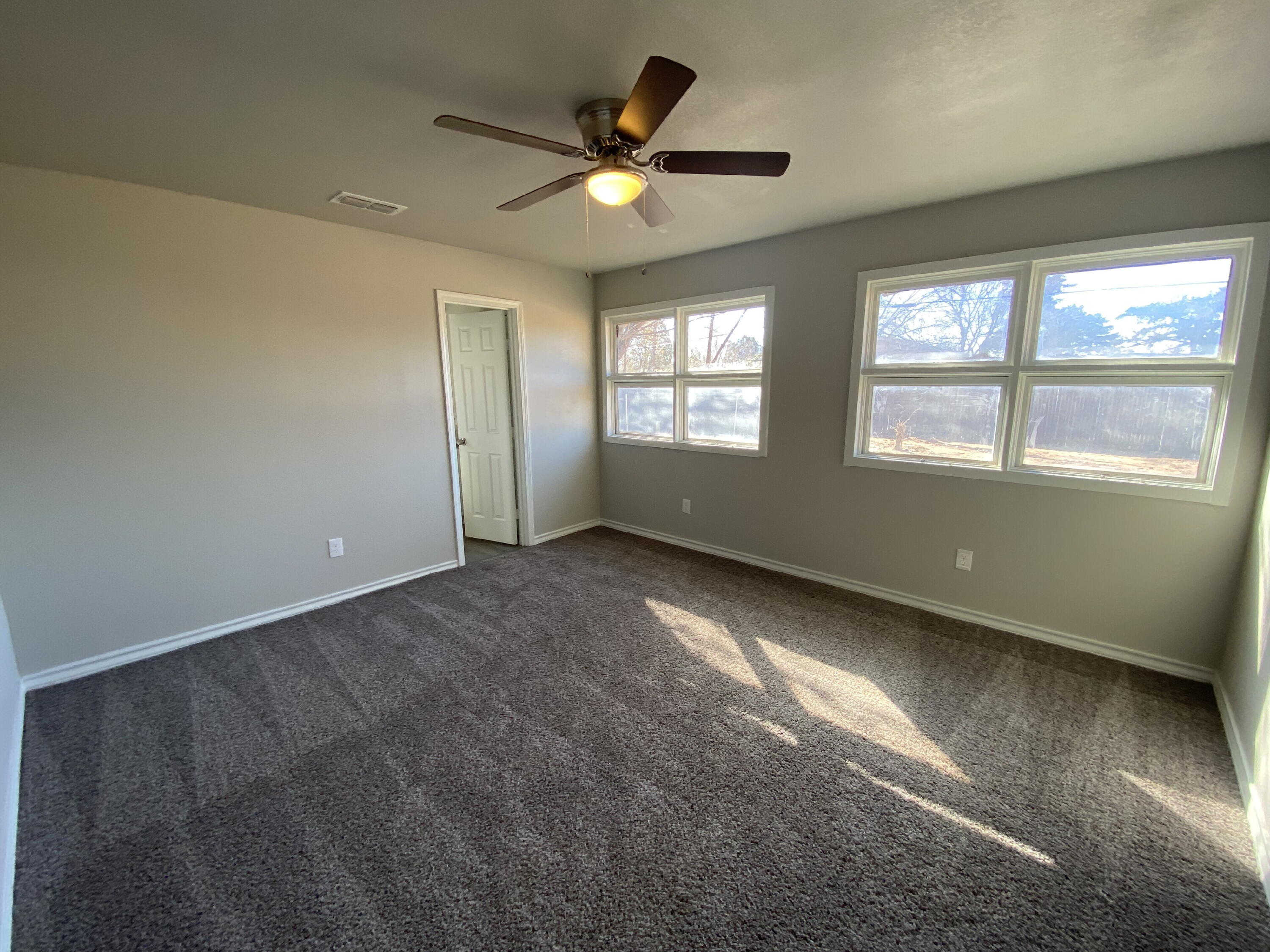 2823 56th Street Lubbock, TX 79413 - Photo 11 of 15 an empty room with windows and ceiling fan