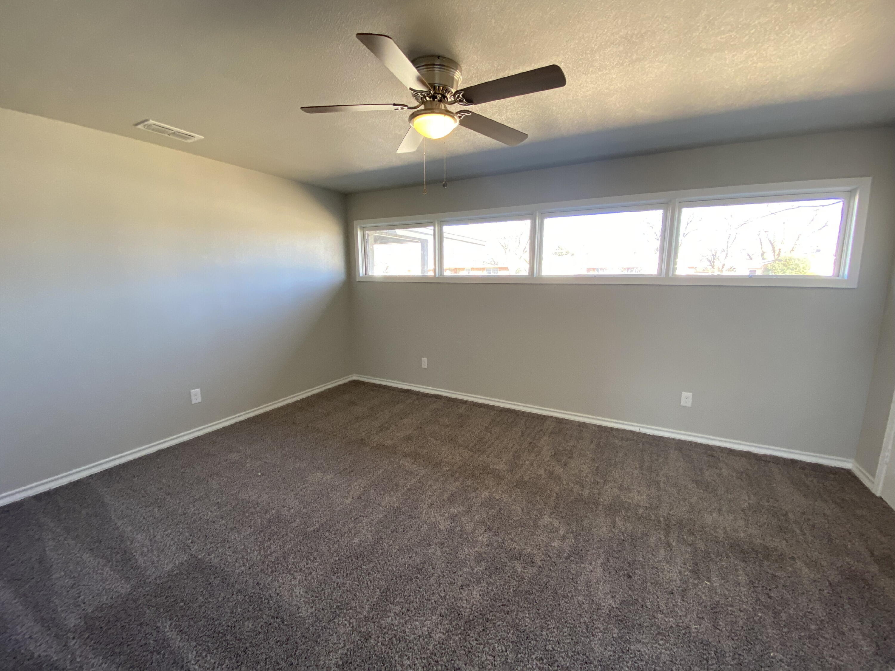 2823 56th Street Lubbock, TX 79413 - Photo 13 of 15 an empty room with a window and a ceiling fan