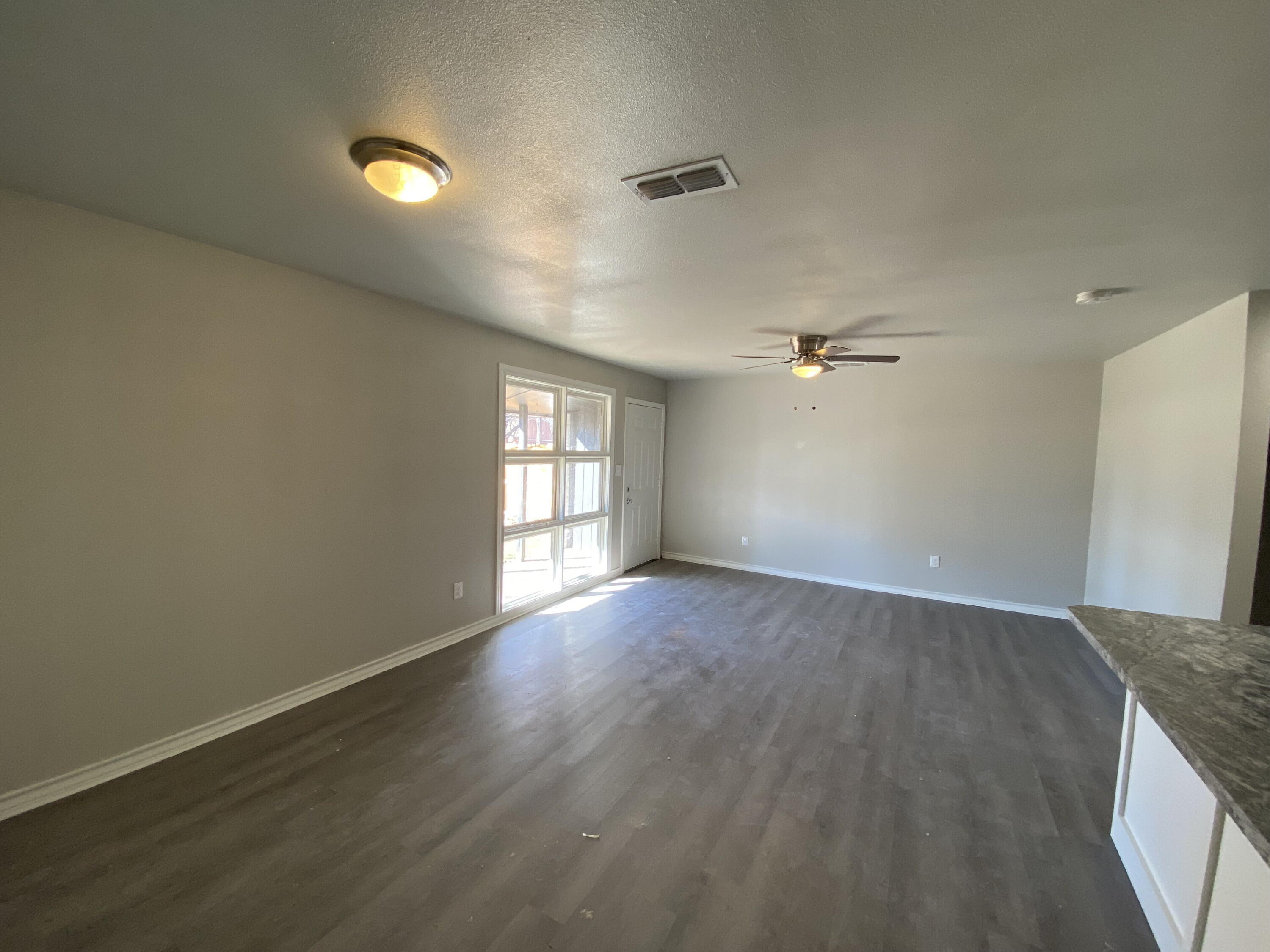 2823 56th Street Lubbock, TX 79413 - Photo 4 of 15 an empty room with wooden floor and windows