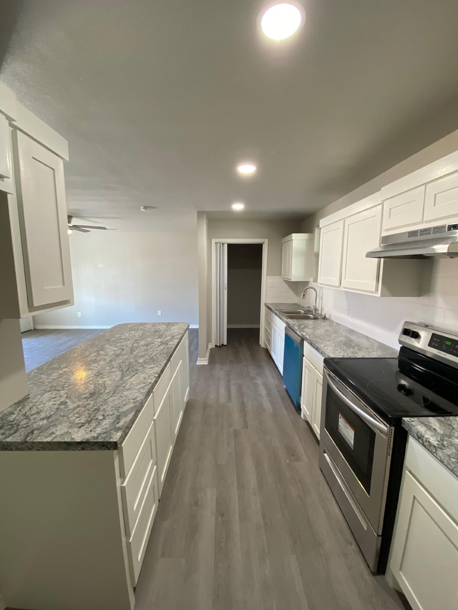 2823 56th Street Lubbock, TX 79413 - Photo 6 of 15 a kitchen with granite countertop a stove and a sink