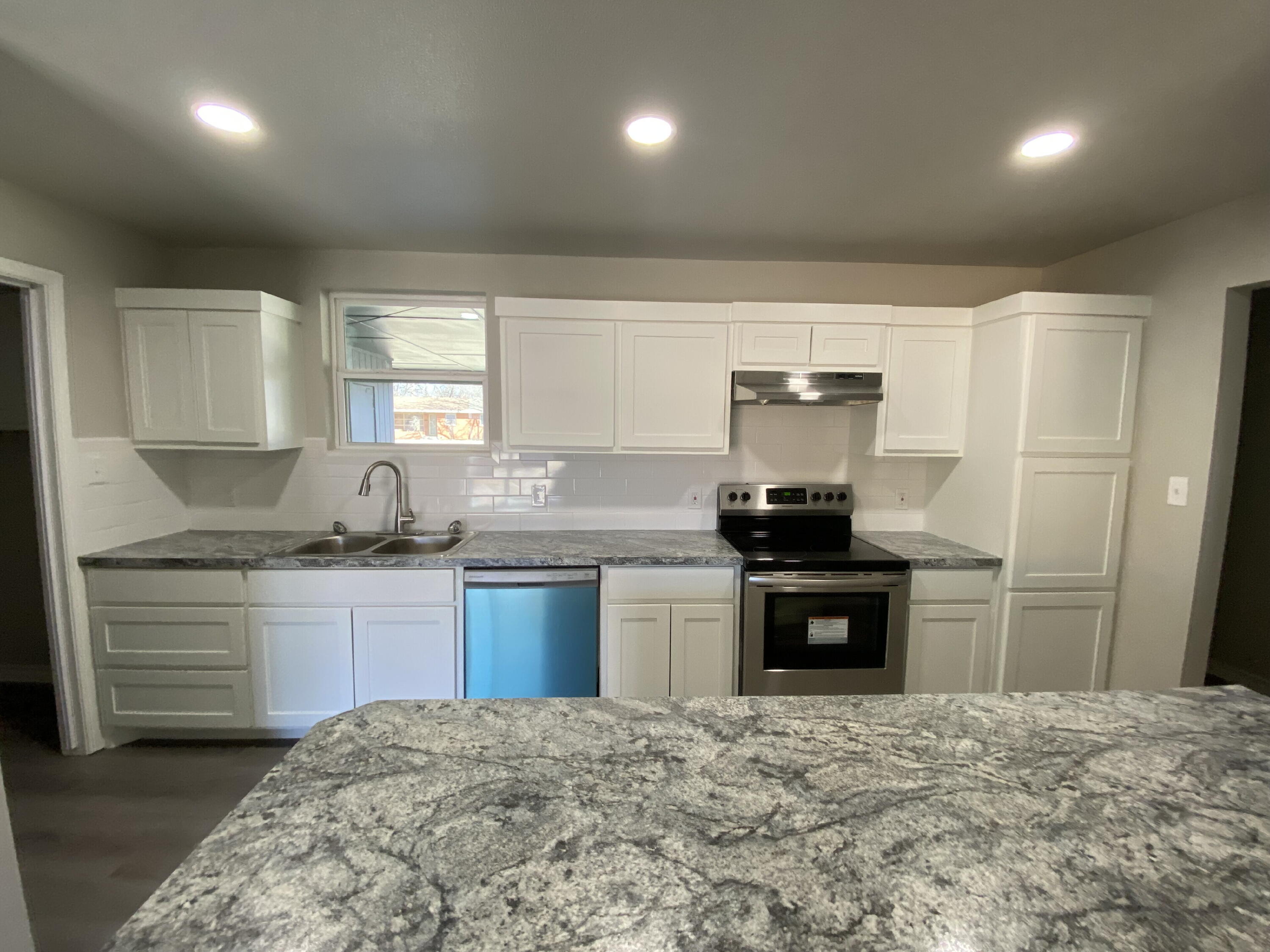 2823 56th Street Lubbock, TX 79413 - Photo 7 of 15 a kitchen with a stove a sink and a refrigerator