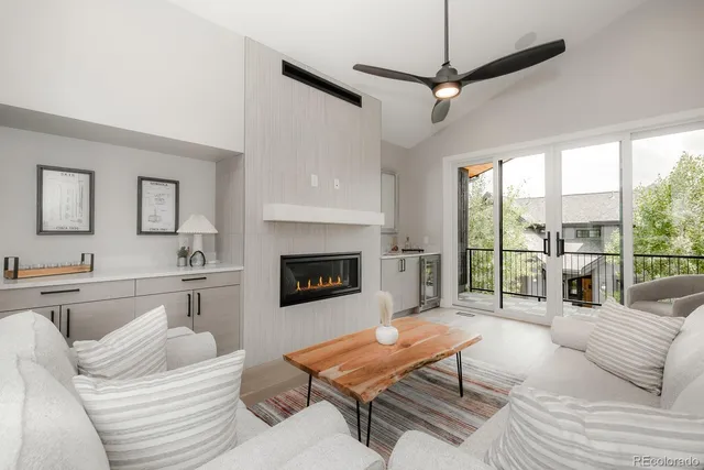 a living room with furniture a large window and a fireplace