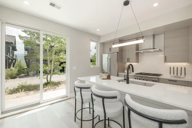 a kitchen with a table chairs stove and wooden floor