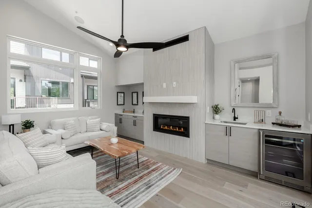 a living room with furniture a fireplace and a ceiling fan