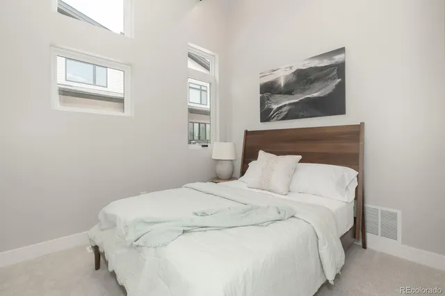 a large bed sitting in a bedroom next to a window