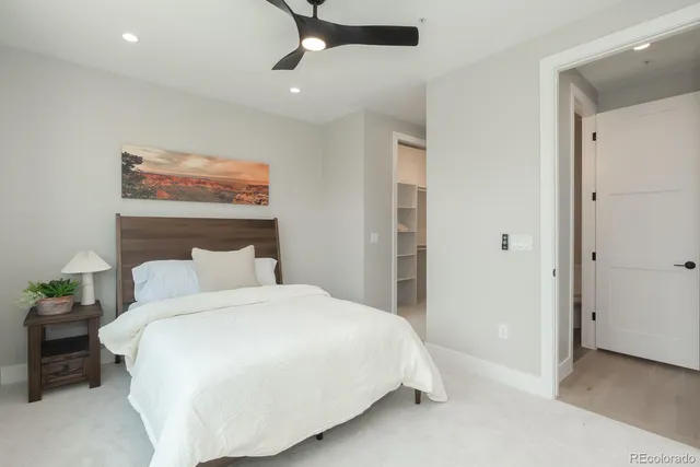 a bedroom with a bed and a painting on the wall