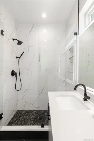a bathroom with a sink a mirror and a shower