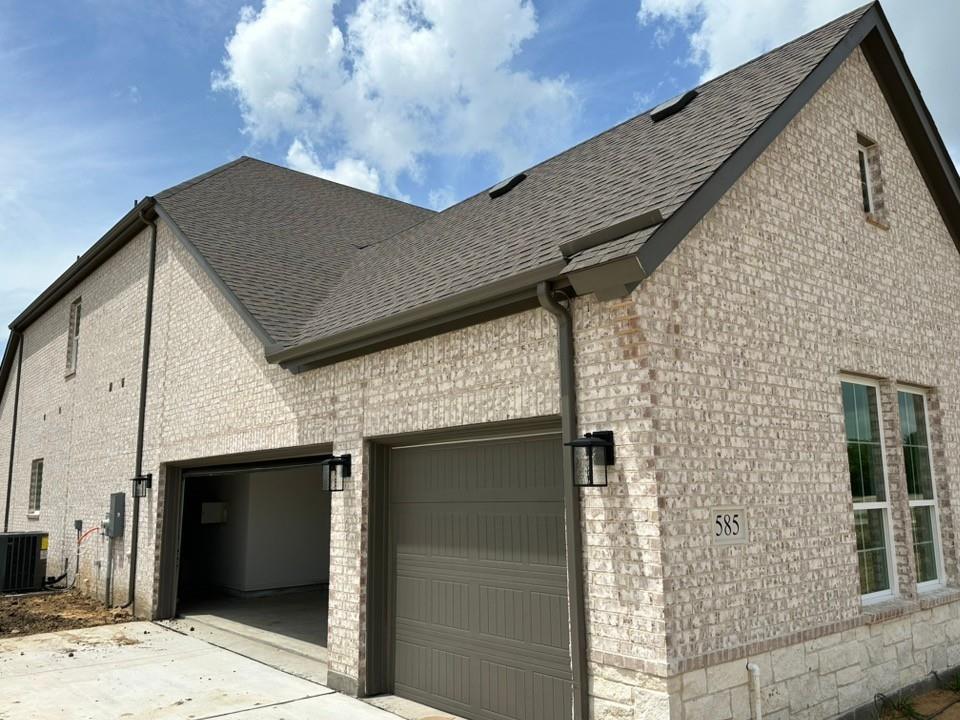 585 Brown Road Leonard, TX 75452 - Photo 3 of 26 Light-colored brick exterior featuring a multi-gabled roofline and a two-car garage