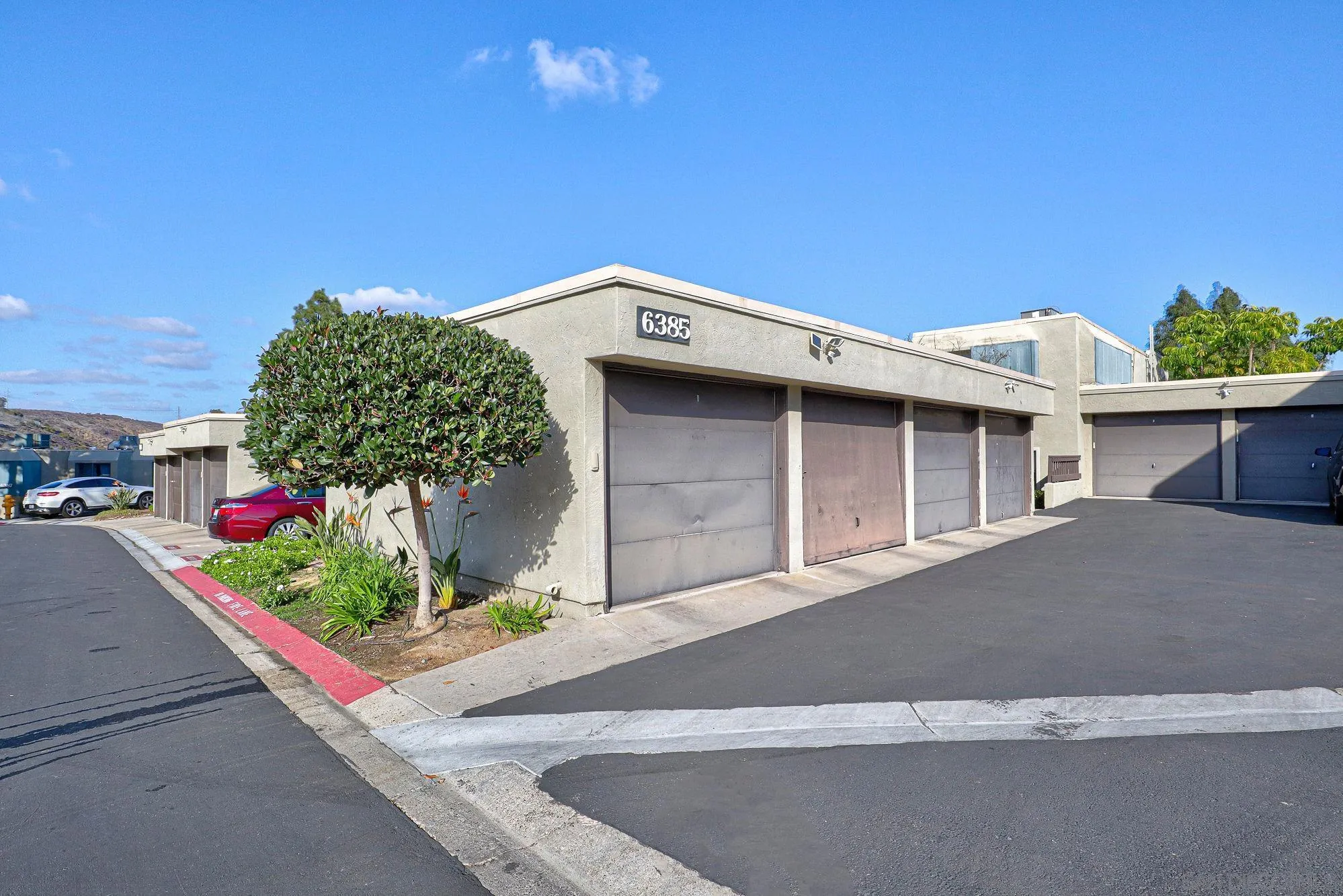6385 Rancho Mission Road, Unit 6 San Diego, CA 92108 - Photo 3 of 26 a front view of a house with a yard and garage