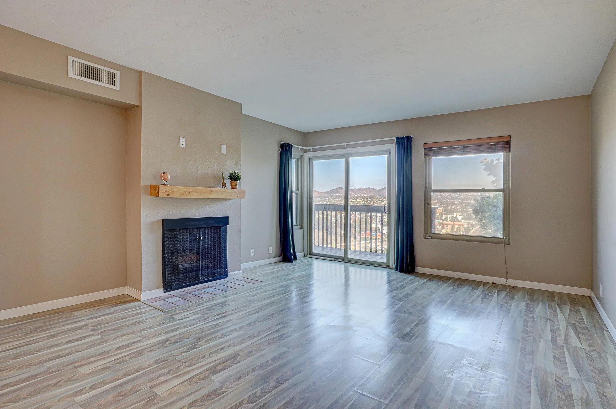 6385 Rancho Mission Road, Unit 6 San Diego, CA 92108 - Photo 8 of 26 an empty room with wooden floor fireplace and windows