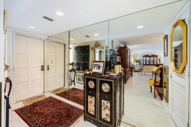 a view of a hallway with dining area mirror and front door