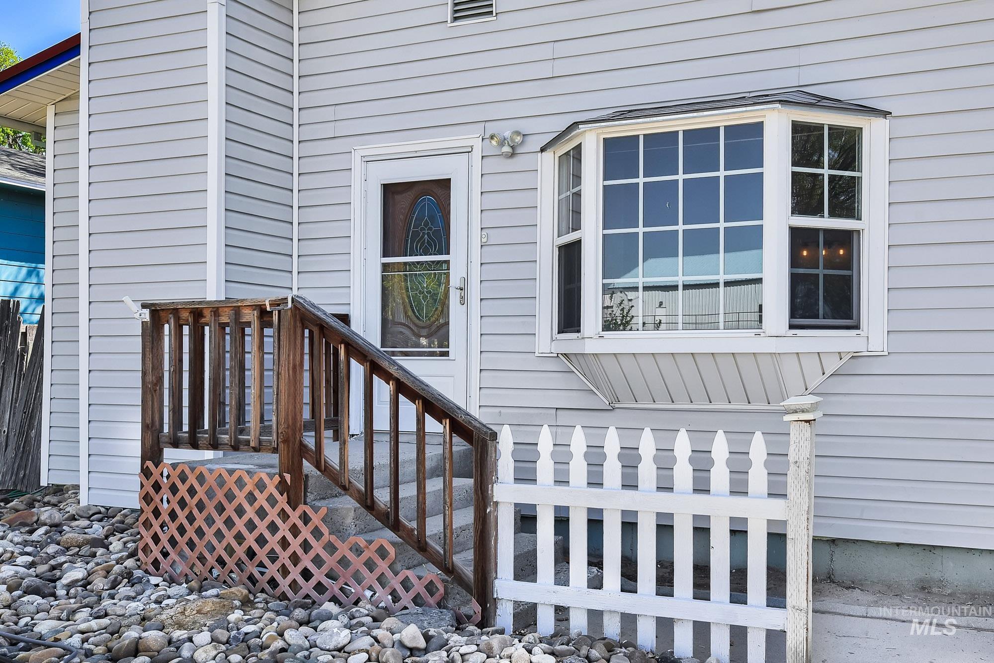 808 North A Street Parma, ID 83660 - Photo 2 of 29 Light gray horizontal siding exterior with a wood entry porch and steps