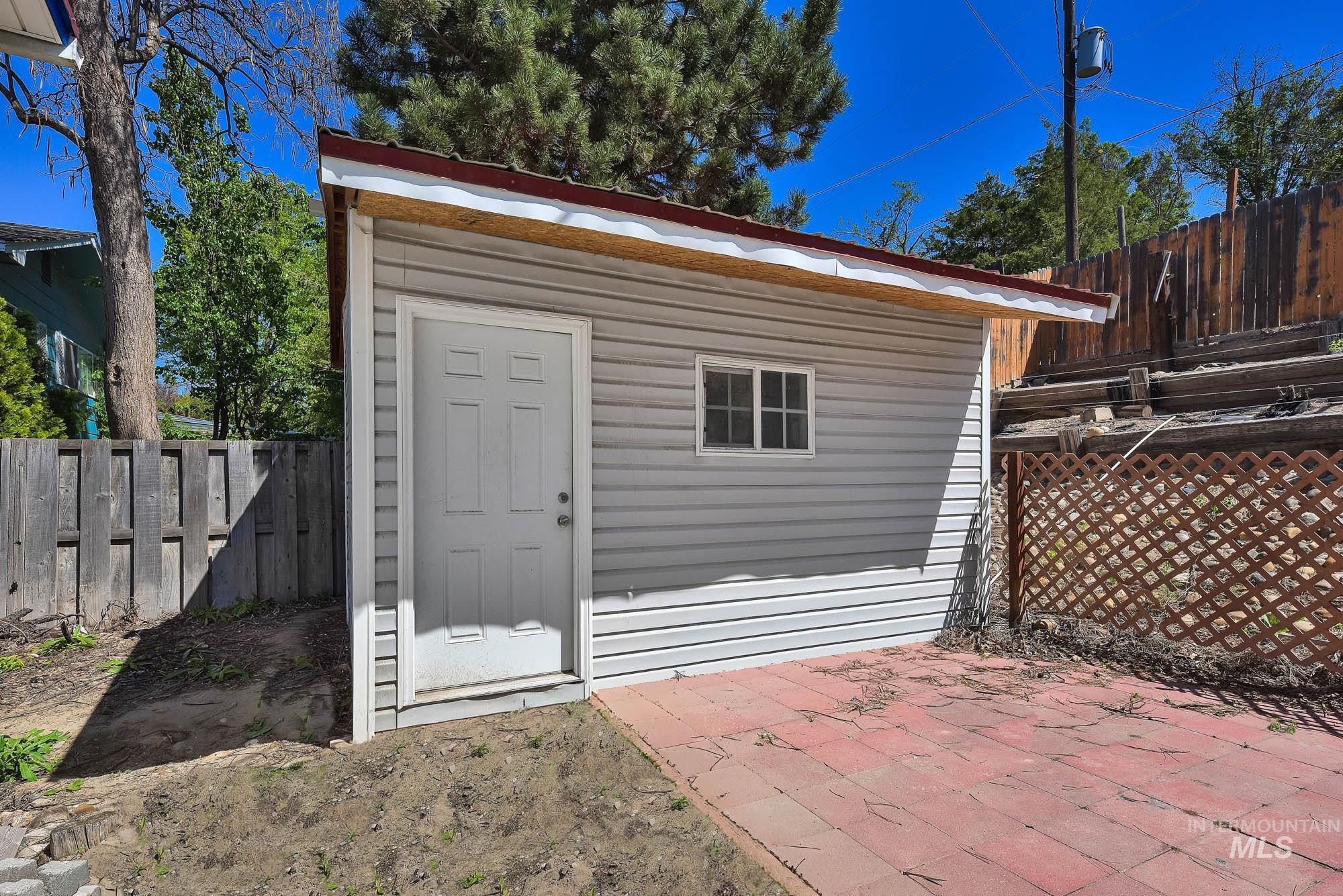 808 North A Street Parma, ID 83660 - Photo 26 of 29 Detached outbuilding with light grey siding, a red metal roof, and a white entrance door