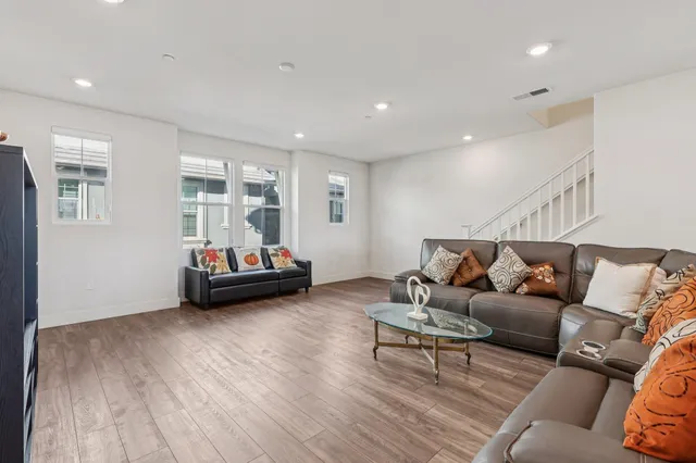 a living room with furniture and a wooden floor