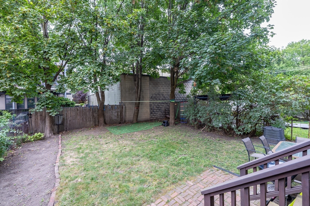 65-67 Allston Street, Unit 1 Cambridge, MA 02139 - Photo 12 of 13 a backyard of a house with lots of plants and tree
