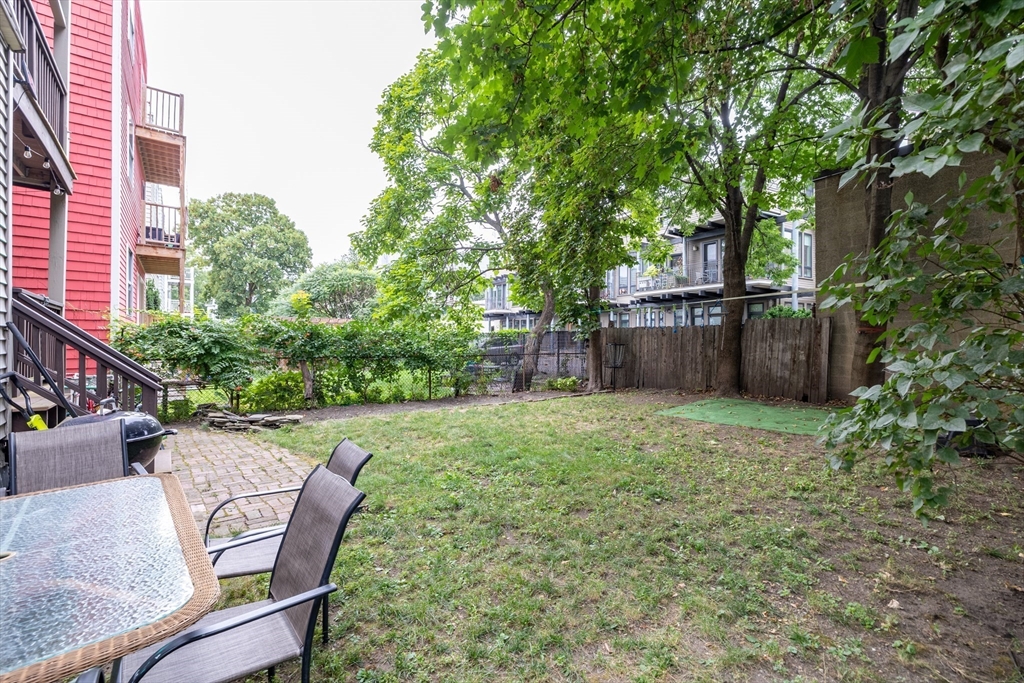 65-67 Allston Street, Unit 1 Cambridge, MA 02139 - Photo 13 of 13 a view of a backyard with furniture and a garden
