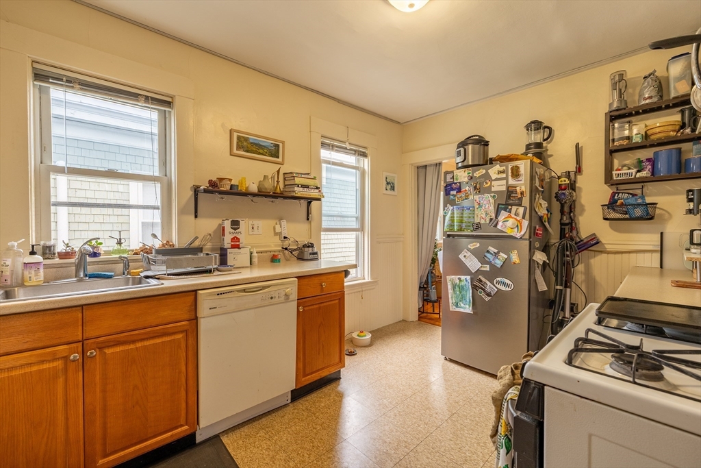 65-67 Allston Street, Unit 1 Cambridge, MA 02139 - Photo 7 of 13 a kitchen with stainless steel appliances granite countertop a refrigerator and a sink