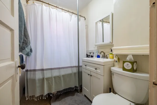 a bathroom with a sink a toilet and shower curtain