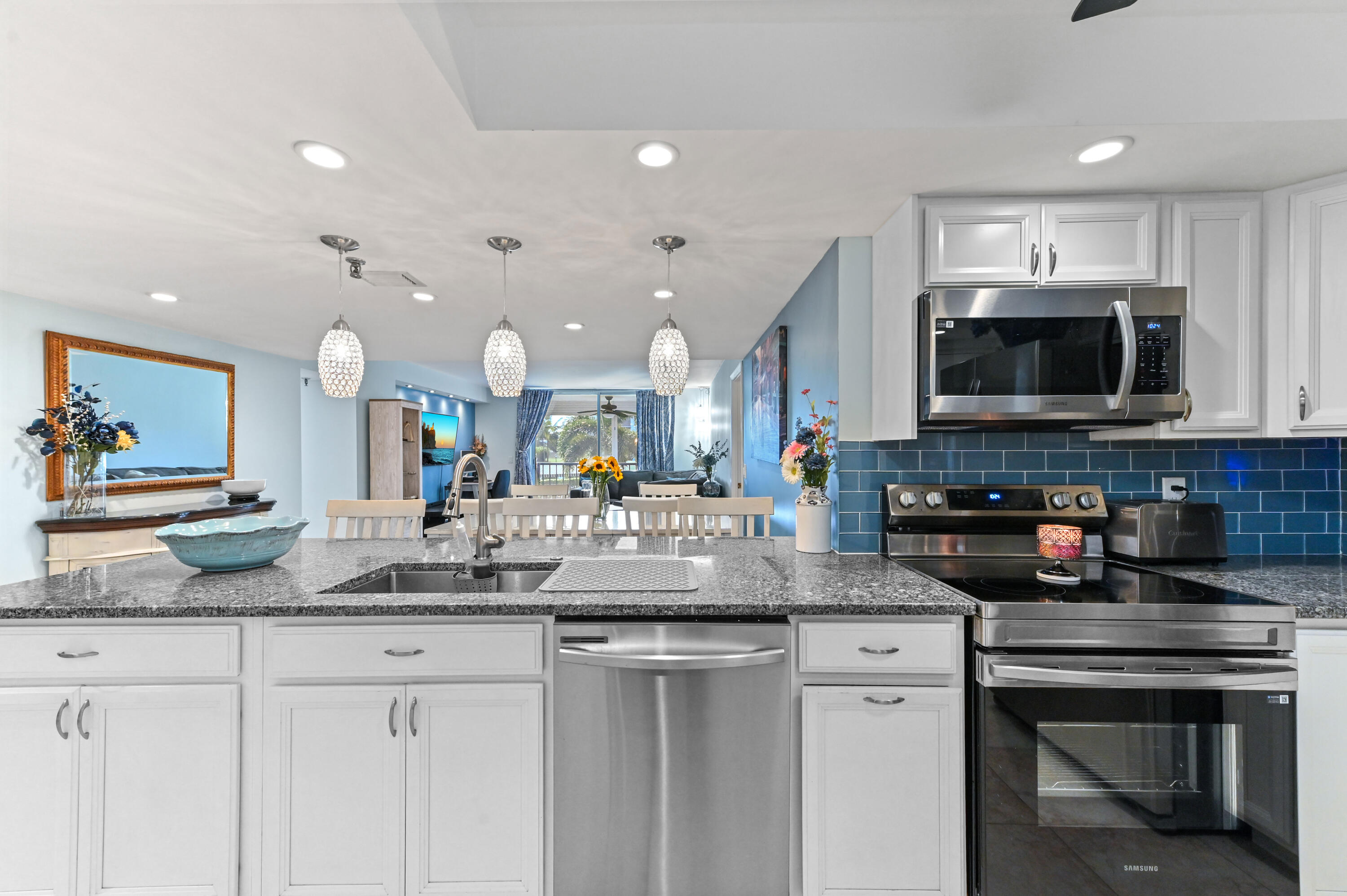 198 Northwest 67th Street, Unit 207 Boca Raton, FL 33487 - Photo 8 of 42 a kitchen with sink a microwave a stove and cabinets