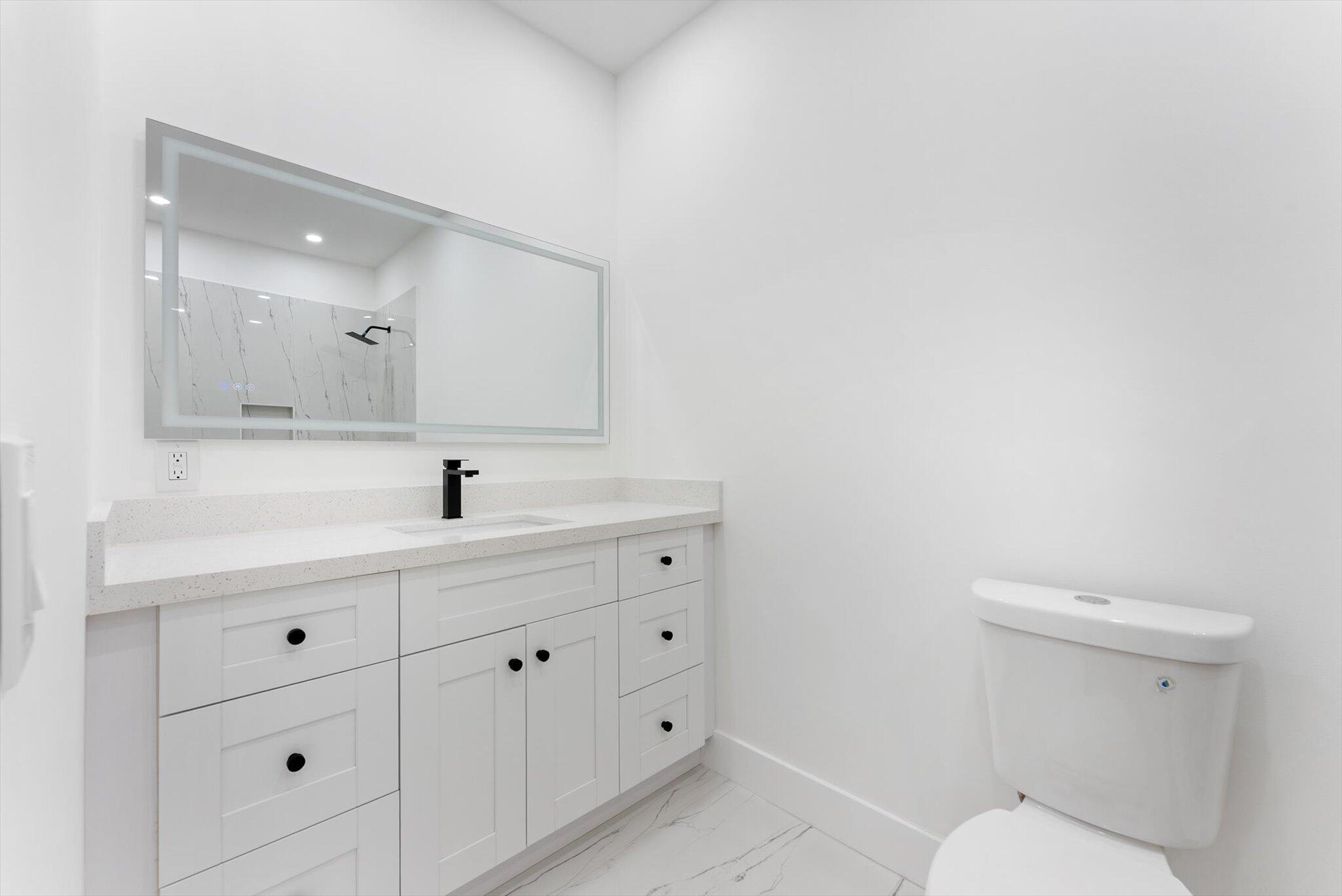 1891 Ridge Road North Palm Beach, FL 33408 - Photo 15 of 24 a bathroom with a toilet sink and mirror