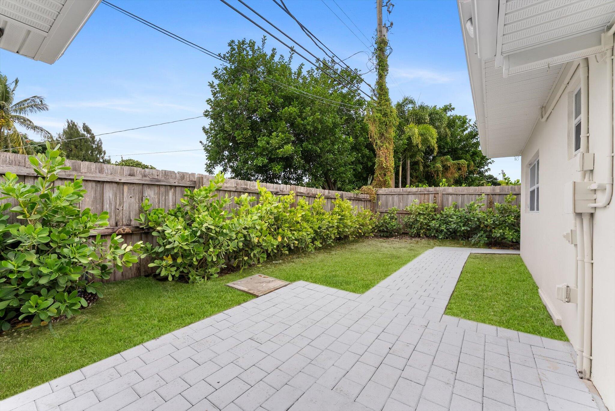 1891 Ridge Road North Palm Beach, FL 33408 - Photo 20 of 24 a view of backyard with potted plants and a palm tree