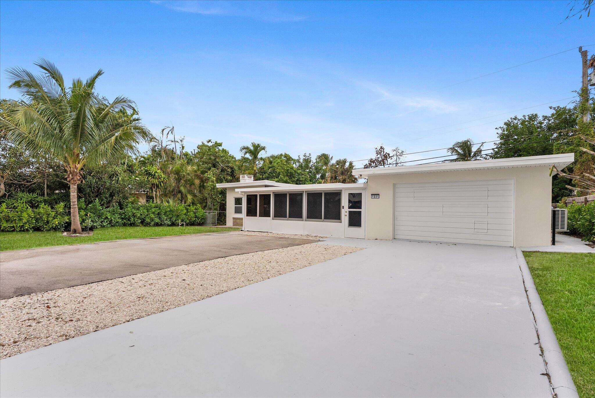 1891 Ridge Road North Palm Beach, FL 33408 - Photo 22 of 24 a front view of a house with a yard and garage
